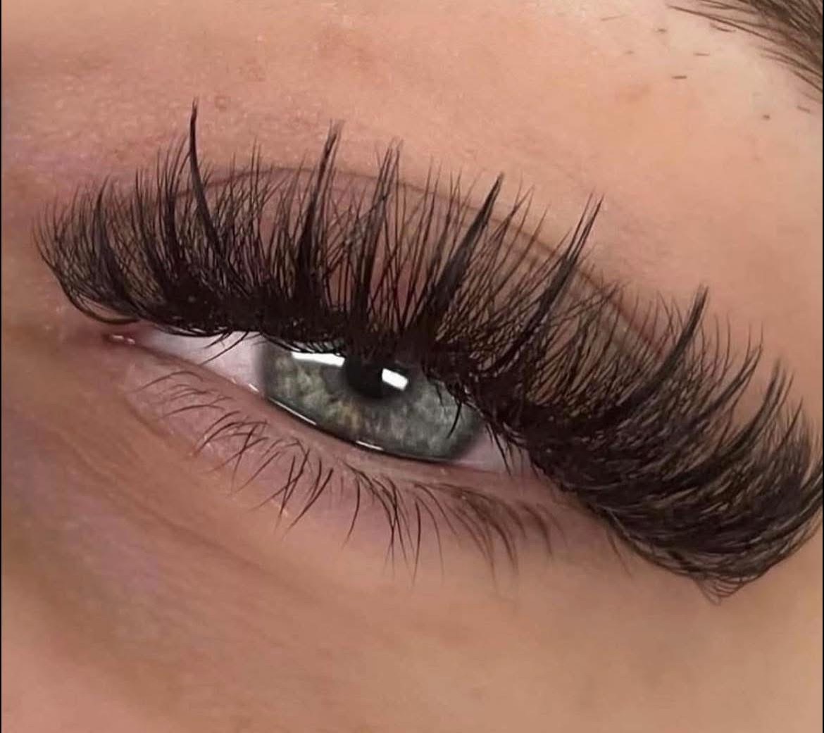 Natürlich gesetztes Volume-Lash-Set an einem grünen Auge