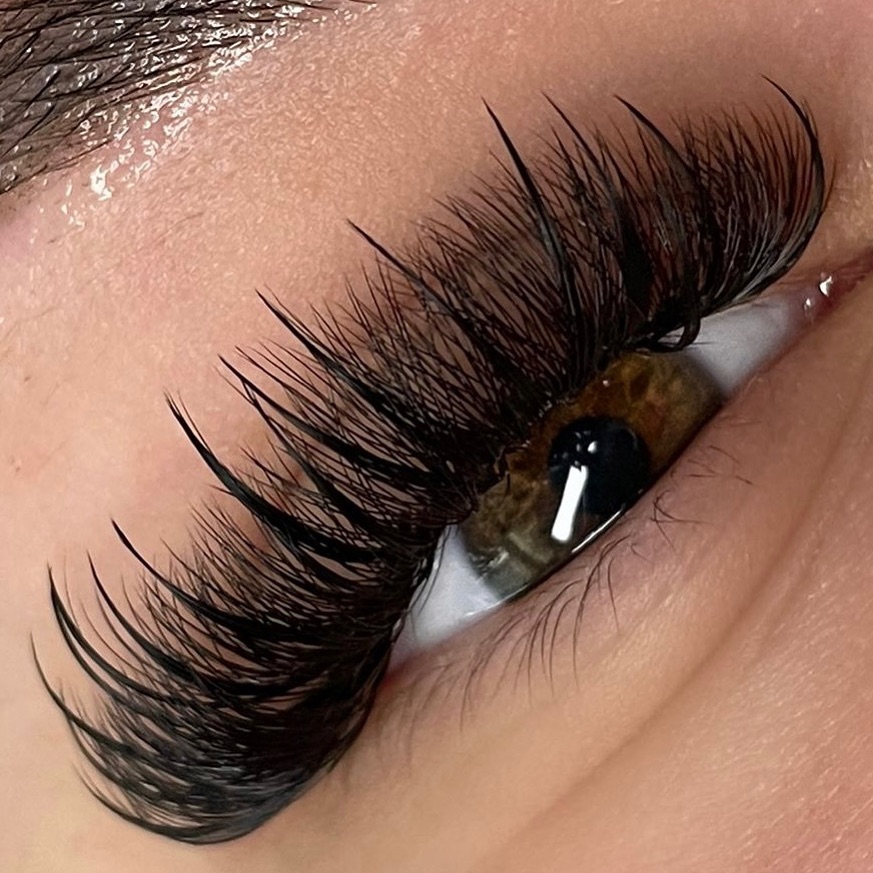 Volume Lashes mit spitzen Längen an einem braunen Auge